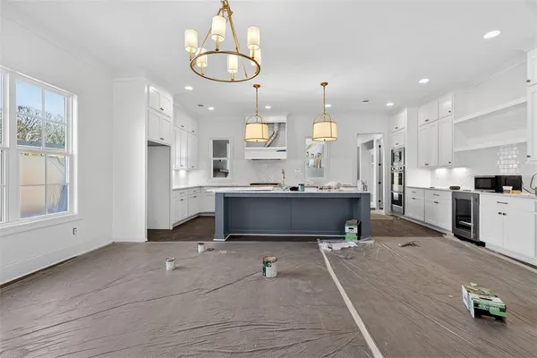 a kitchen with kitchen island granite countertop a sink a counter space appliances and cabinets