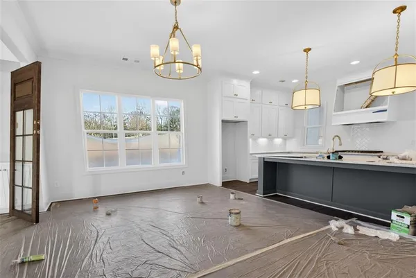 a kitchen with stainless steel appliances granite countertop a sink a stove and a wooden floors