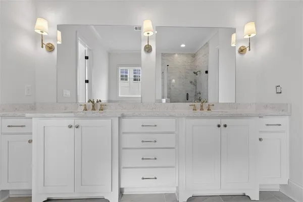 a bathroom with a granite countertop bathtub shower sink vanity and toilet