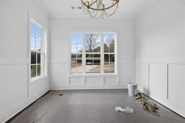 a view of an empty room with window and wooden floor
