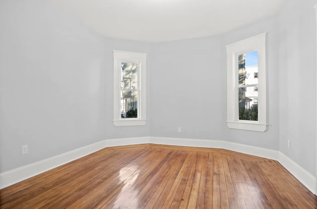 10 Sutton Street Boston, MA 02126 - Photo 15 of 24 an empty room with wooden floor and windows