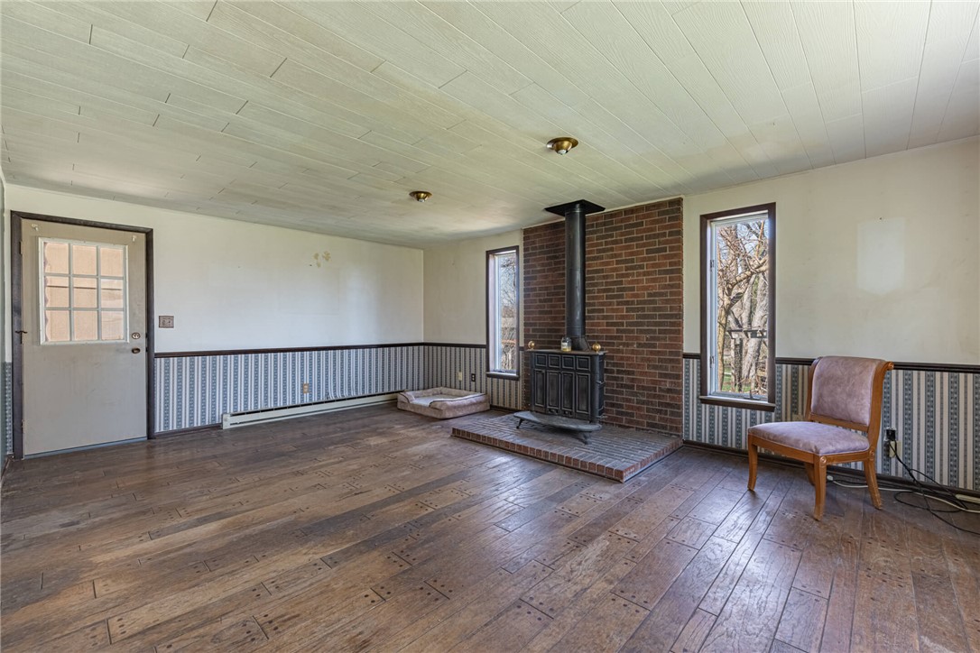 6885 Garber Road Clayton, OH 45415 - Photo 17 of 24 This living room features rich wood flooring, a charming fireplace, and abundant natural light.