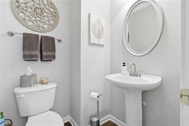 a bathroom with a toilet a sink and mirror