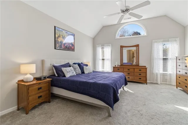 a spacious bedroom with a bed a chandelier and a dresser