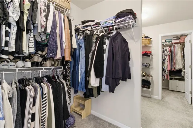 a view of walk in closet with clothes and shoes