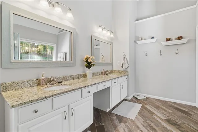 a spacious bathroom with a granite countertop sink and a mirror
