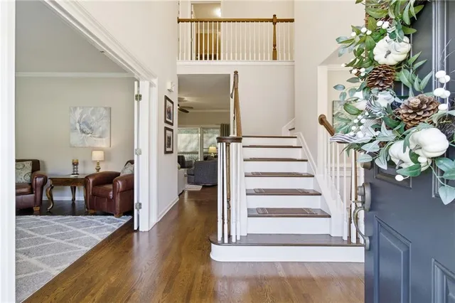 a view of a hallway to a livingroom with wooden floor and furniture