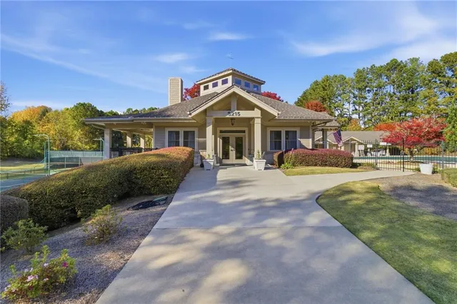 a front view of a house with a yard and potted plants