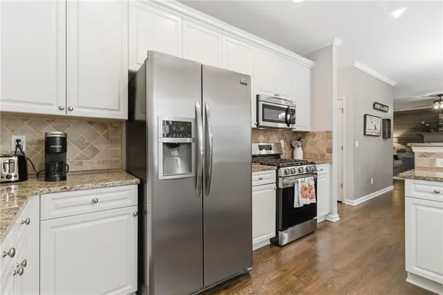 a kitchen with stainless steel appliances kitchen island a refrigerator sink and stove