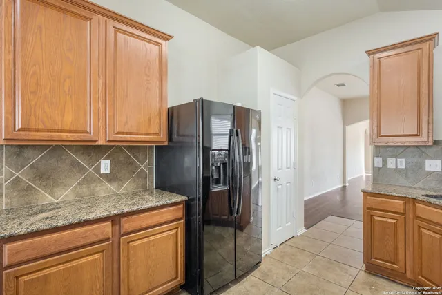 a kitchen with stainless steel appliances granite countertop a refrigerator and a sink
