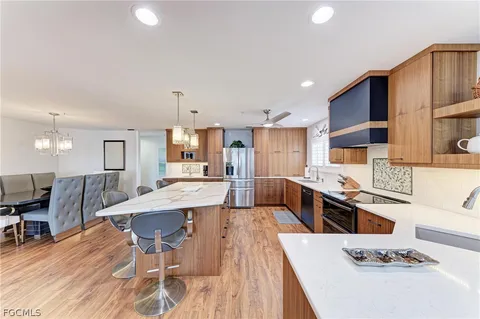 a large kitchen with stainless steel appliances kitchen island granite countertop a sink and cabinets