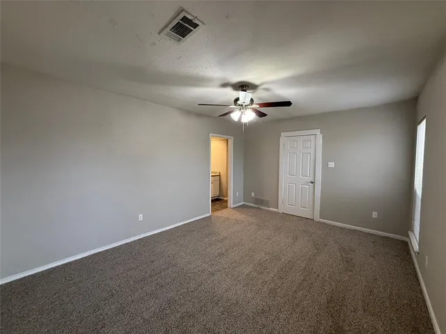 a view of an empty room with a chandelier fan
