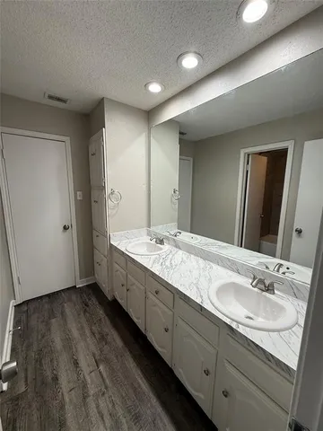a bathroom with double vanity sink and a mirror