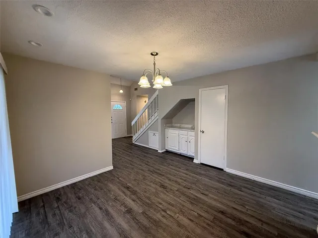 an empty room with wooden floor ceiling fan and window