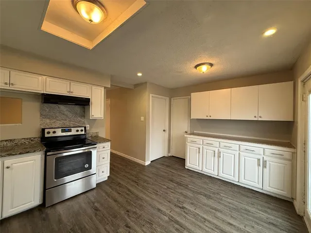 a kitchen with stainless steel appliances granite countertop a stove a sink and a microwave
