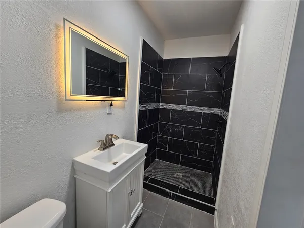 a bathroom with a sink toilet and shower