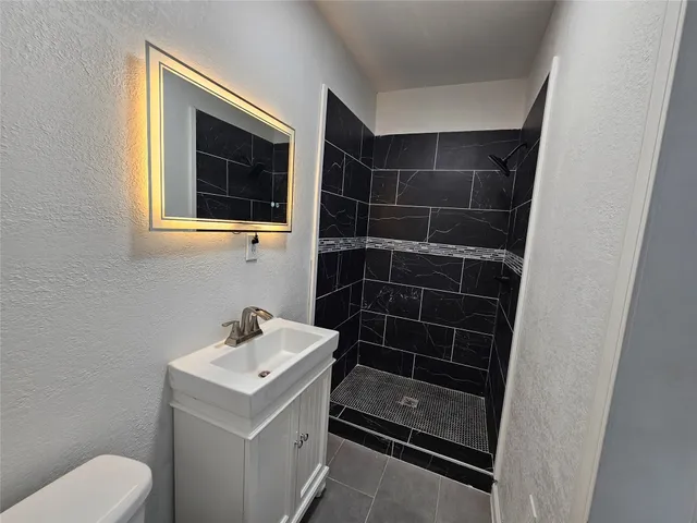 a bathroom with a sink toilet and shower