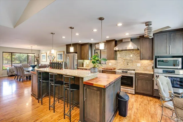 a kitchen with kitchen island granite countertop lots of counter top space and stainless steel appliances