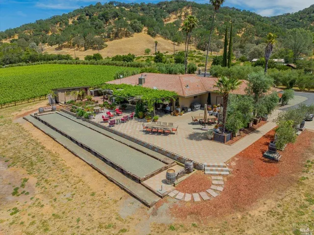 an aerial view of a house with a garden and lake view