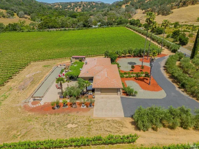 an aerial view of a house with a garden and lake view