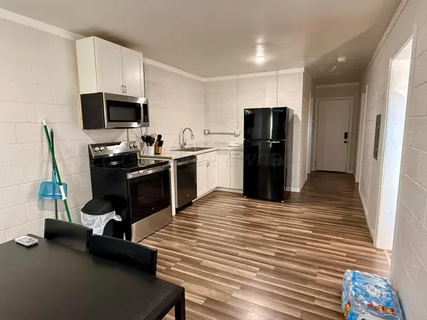 a kitchen with a refrigerator and a stove top oven