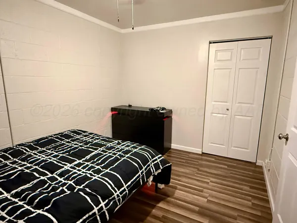 a bedroom with a bed and wooden floor