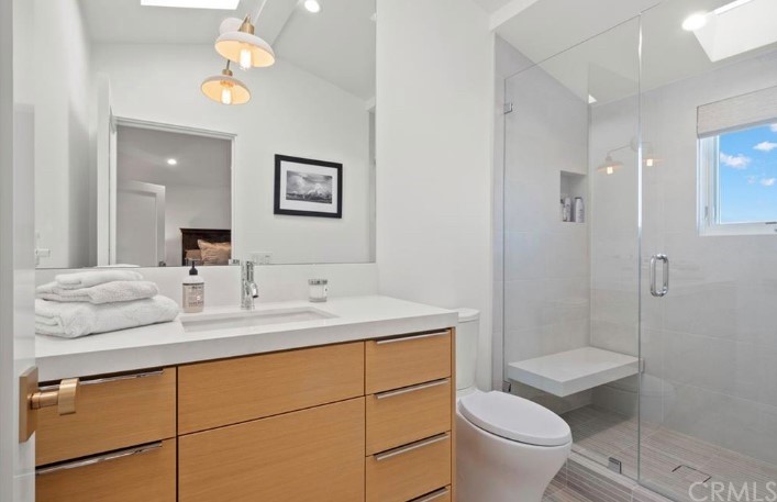 304 Iris Avenue Corona del Mar, CA 92625 - Photo 12 of 19 a bathroom with a granite countertop sink a toilet a mirror and shower