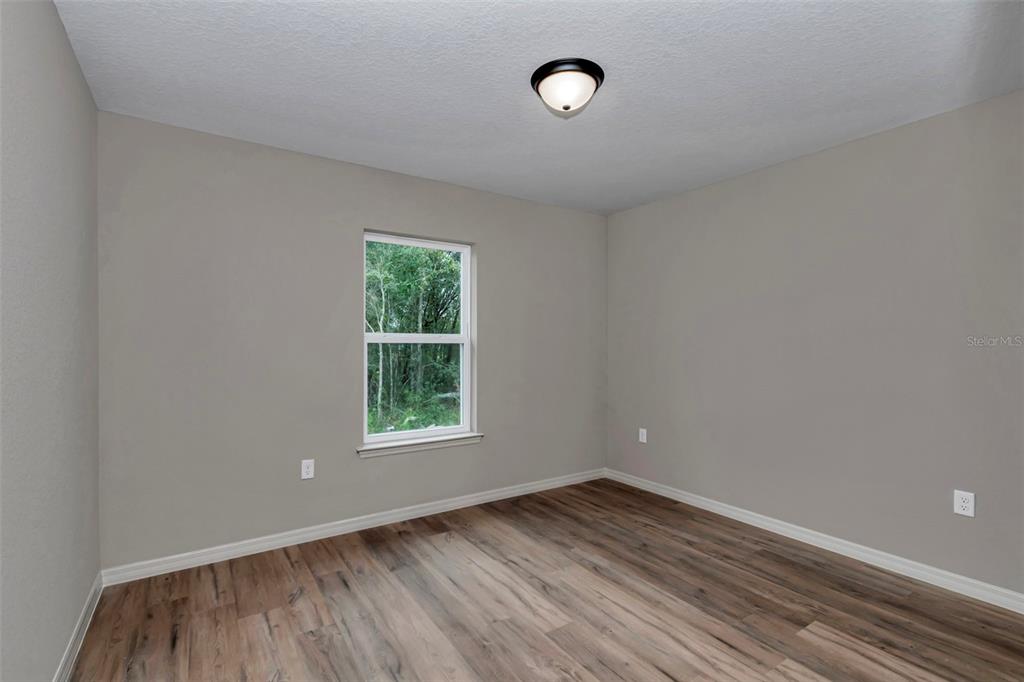 21 Pine Course Pass Ocala, FL 34472 - Photo 2 of 29 an empty room with wooden floor and windows