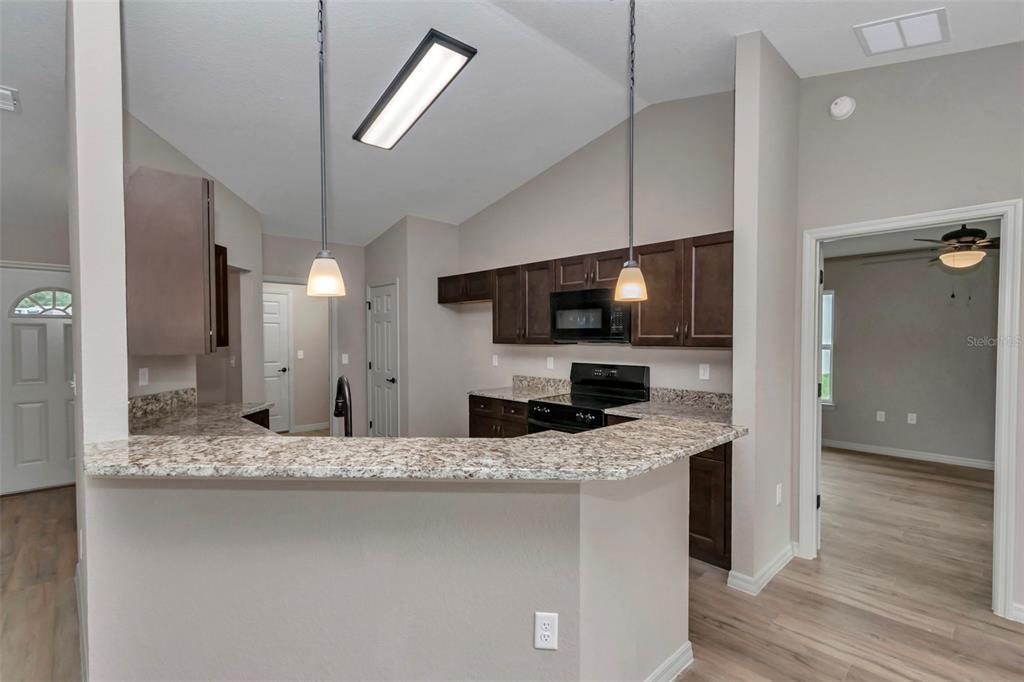 21 Pine Course Pass Ocala, FL 34472 - Photo 22 of 29 a kitchen with stainless steel appliances kitchen island granite countertop a sink and a microwave