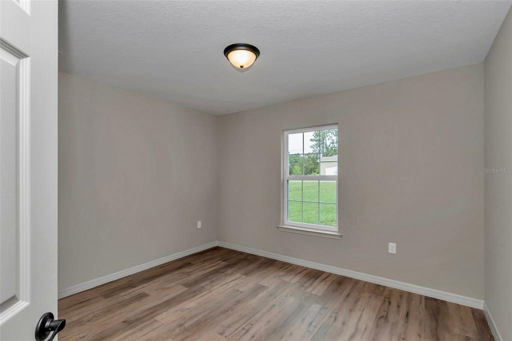 21 Pine Course Pass Ocala, FL 34472 - Photo 6 of 29 an empty room with wooden floor and windows