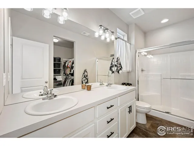 a bathroom with a double vanity sink mirror double and toilet