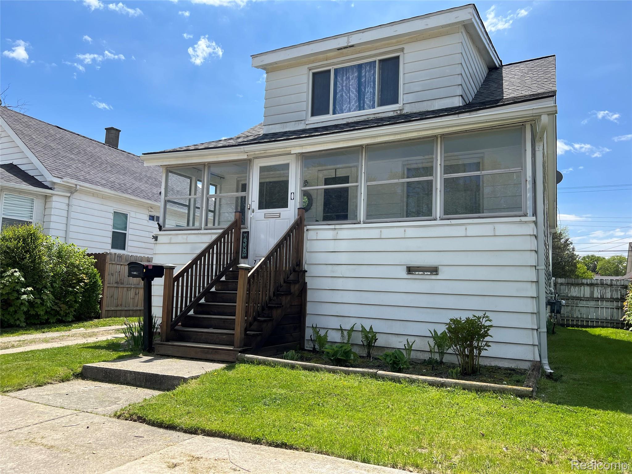 7352 Dale Center Line, MI 48015 - Photo 1 of 22 Two-story residence featuring a screened-in front porch with wooden steps and railing