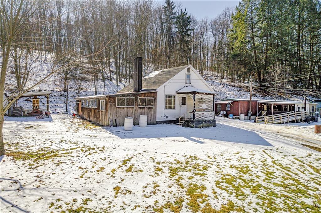 a front view of a house with a yard covered in snow