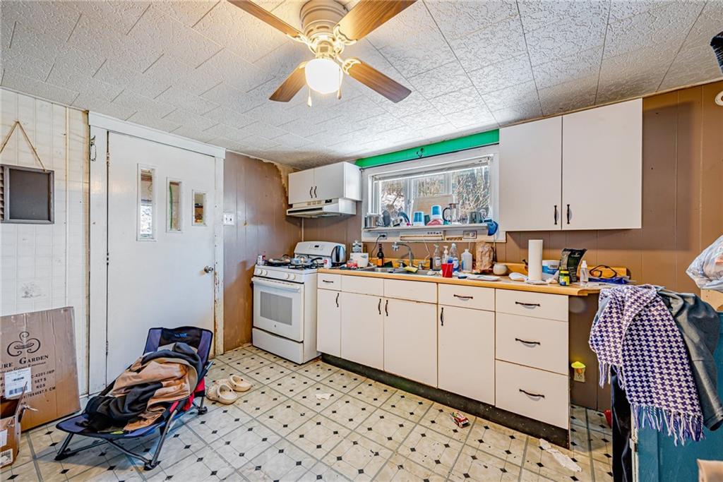 1249 Ridge Road Templeton, PA 16259 - Photo 25 of 37 a kitchen with granite countertop cabinets a stove a sink and a dining table