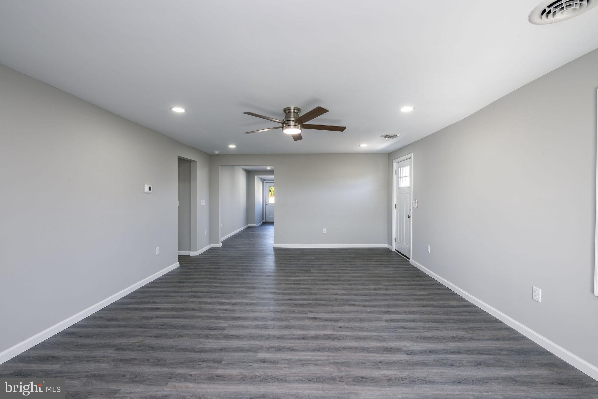 24532 Deep Branch Road Georgetown, DE 19947 - Photo 18 of 43 a view of an empty room with wooden floor and a ceiling fan