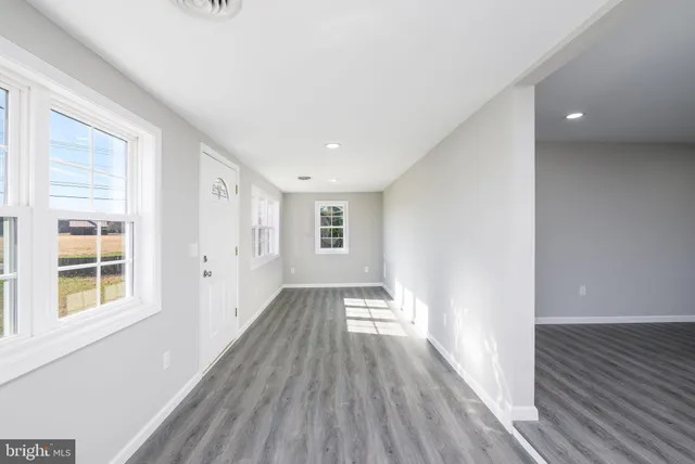 a view of a room with wooden floor and windows