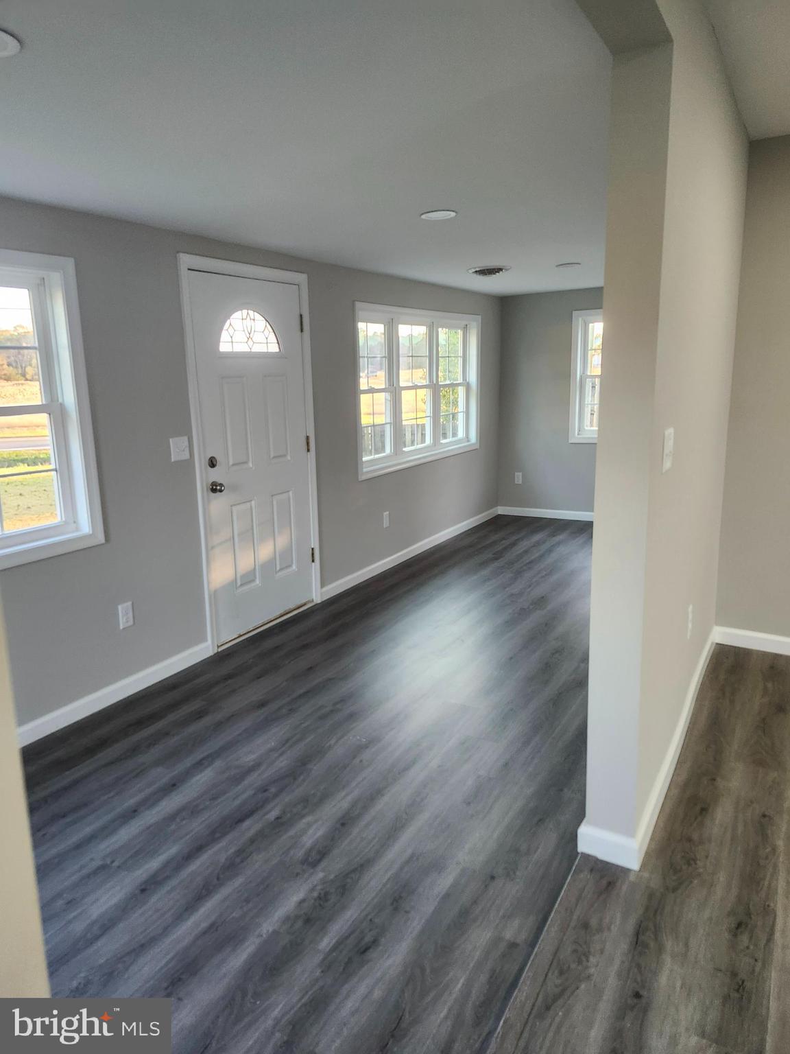 24532 Deep Branch Road Georgetown, DE 19947 - Photo 2 of 43 an empty room with wooden floor and windows