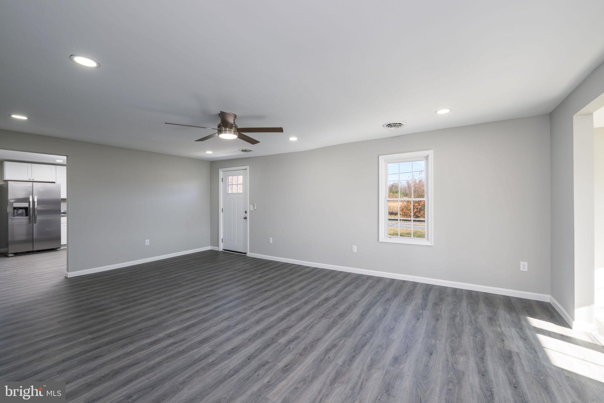 24532 Deep Branch Road Georgetown, DE 19947 - Photo 21 of 43 an empty room with wooden floor cabinet and windows