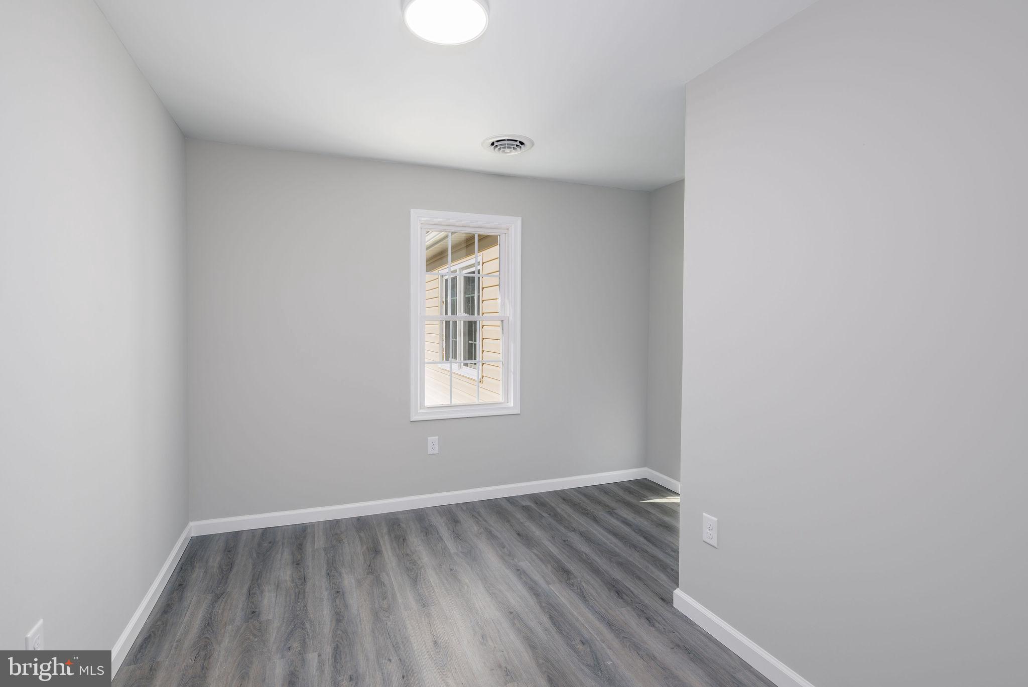 24532 Deep Branch Road Georgetown, DE 19947 - Photo 22 of 43 a view of an empty room with wooden floor and a window