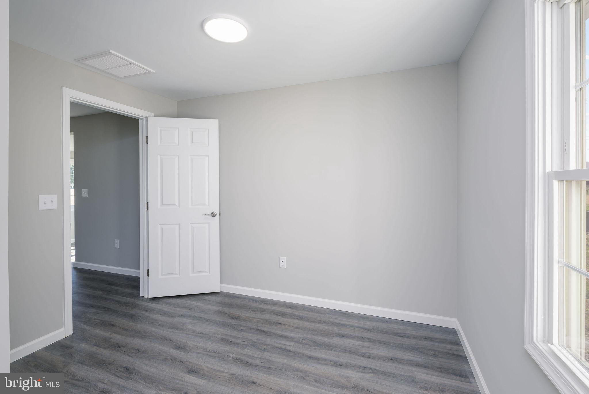 24532 Deep Branch Road Georgetown, DE 19947 - Photo 23 of 43 an empty room with wooden floor and windows