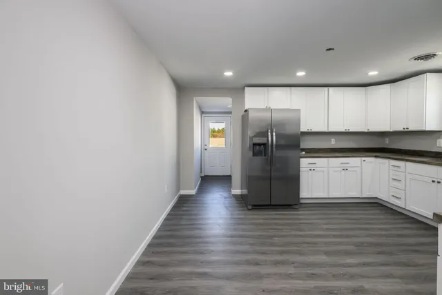 a kitchen with granite countertop white cabinets and stainless steel appliances