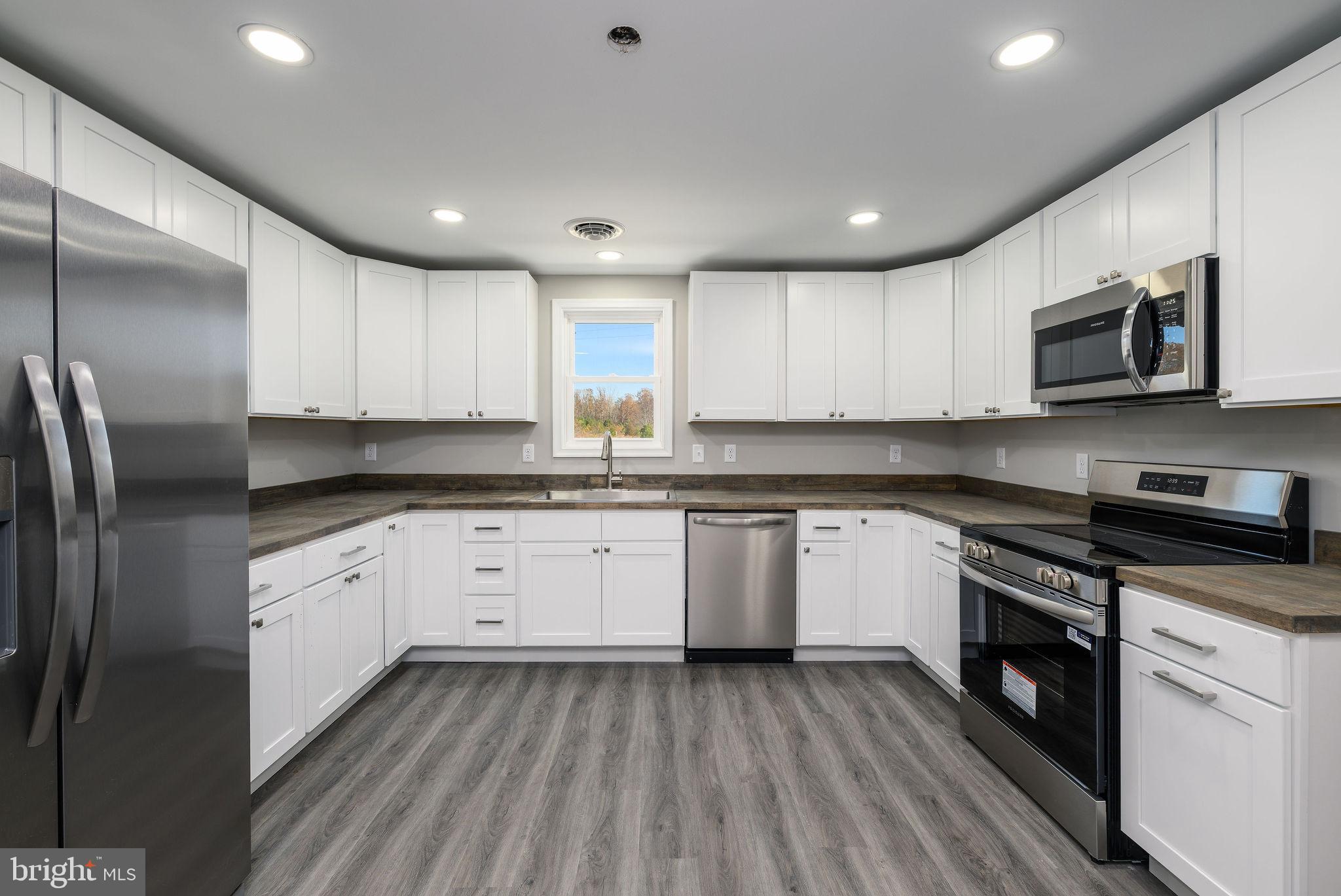24532 Deep Branch Road Georgetown, DE 19947 - Photo 25 of 43 a kitchen with stainless steel appliances granite countertop a stove a sink and a microwave