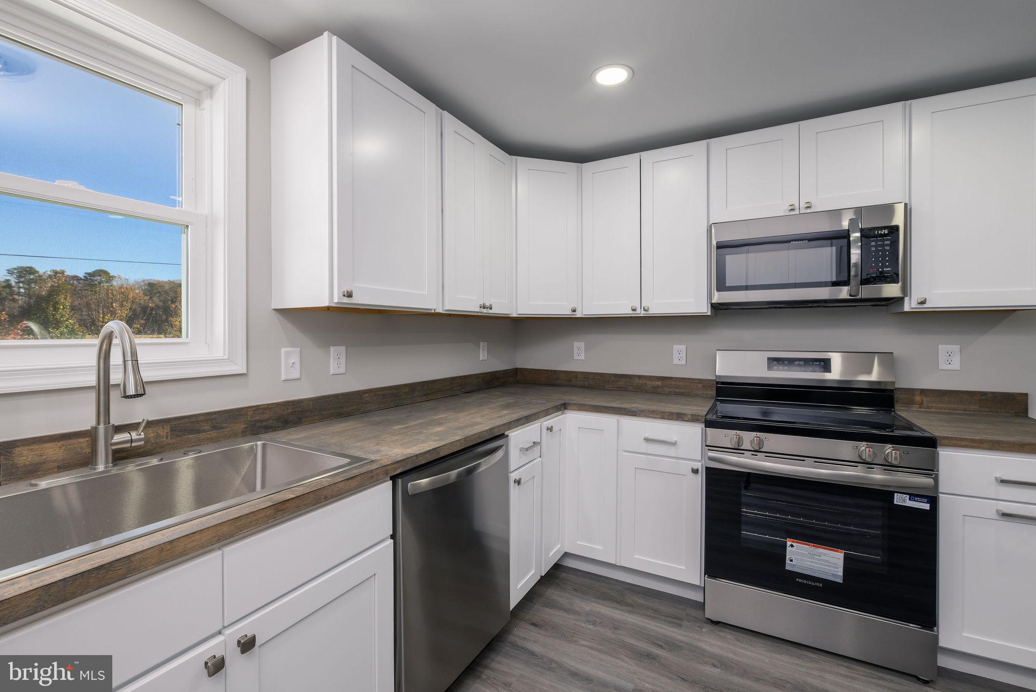 24532 Deep Branch Road Georgetown, DE 19947 - Photo 26 of 43 a kitchen with granite countertop white cabinets appliances and a sink