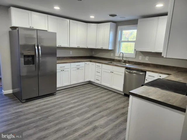 a kitchen with stainless steel appliances granite countertop a refrigerator sink and cabinets