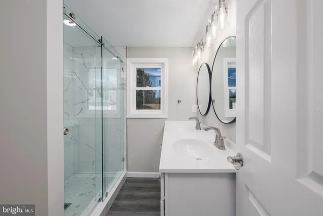 a bathroom with a sink a mirror and shower