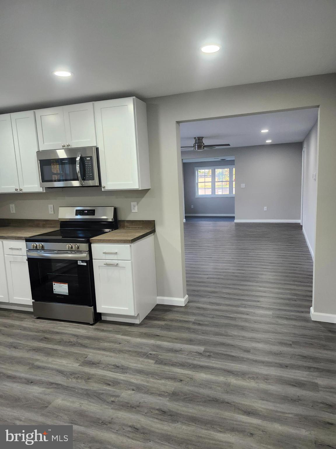 24532 Deep Branch Road Georgetown, DE 19947 - Photo 4 of 43 a kitchen with stainless steel appliances granite countertop a stove a sink and a microwave