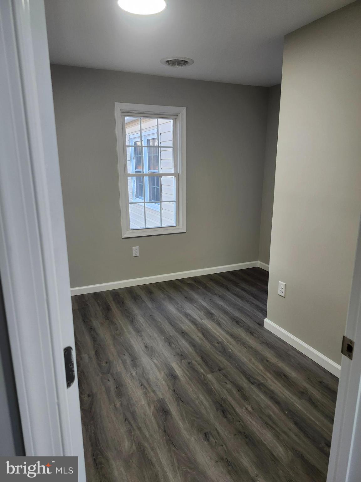 24532 Deep Branch Road Georgetown, DE 19947 - Photo 9 of 43 an empty room with wooden floor and windows