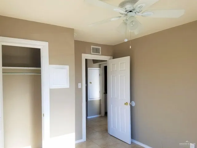 a view of a hallway with a chandelier fan and a closet