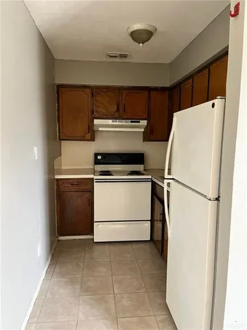 a white refrigerator freezer and a stove sitting inside of a kitchen