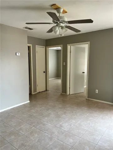 an empty room with a fan and a ceiling fan